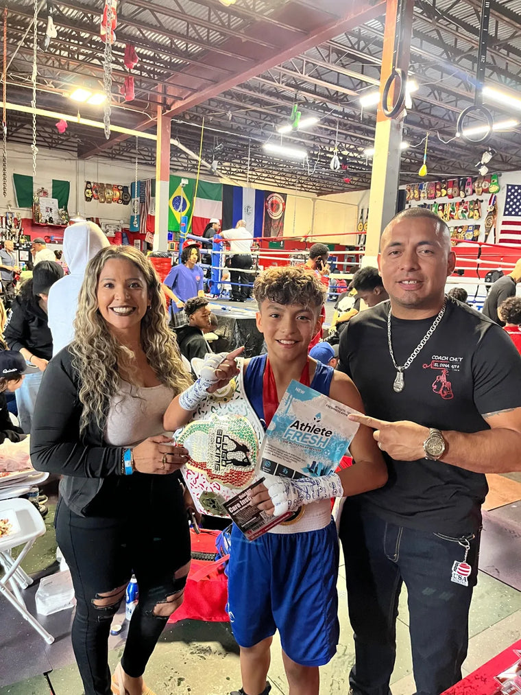 Young boxer with his gold medal and a bag of Athlete Fresh ringside after his win